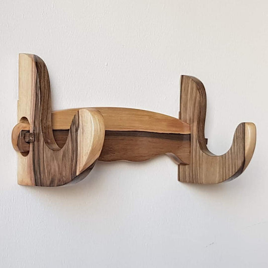 A wall mounted wooden rack designed to hold a sword, ax, or rifle, featuring a natural walnut finish.