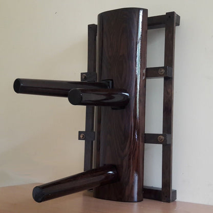 A compact Wing Chun wooden dummy with no legs, mounted on a stand, finished in ash brown.